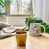 gold tea strainer with plants